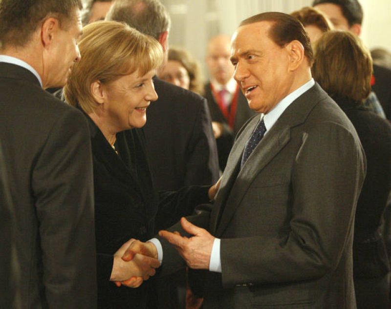 German Chancellor Angela Merkel greets Italian Prime Minister Silvio Berlusconi at a reception at Bellevue Castle in Berlin
