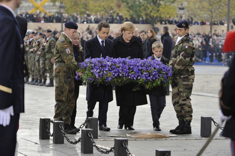 Merkel y Sarkozy depositan un ramo de flores en la Tumba del Soldado Desconocido en el Arco del Triunfo en París.