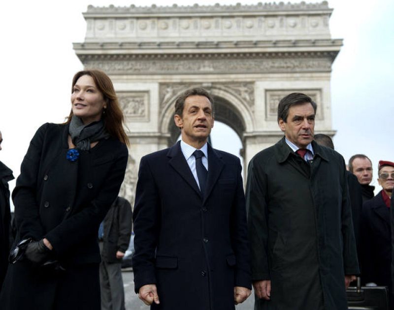 El presidente francés, Nicolas Sarkozy, acompañado de su esposa, Carla Bruni, y el primer ministro, Francois Fillon, abandonan el acto de conmemoración del armisticio que puso fin a la Primera Guerra Mundial. 