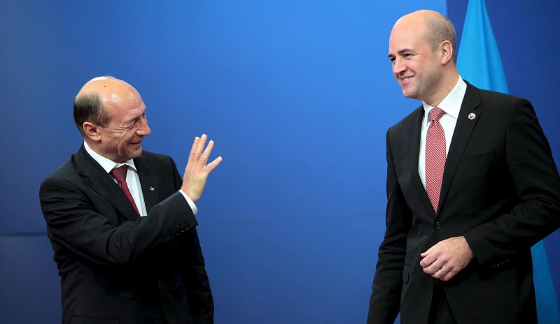 El primer ministro sueco, Fredrik Reinfeldt, cuyo país ejerce la presidencia de turno de la Unión Europea (UE), da la bienvenida al presidente de Rumanía, Traian Basescu, antes de una cena con motivo de la reunión de líderes de la UE, en Bruselas, Bé