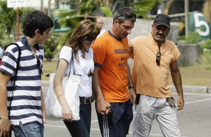 A crew member of the Spanish fishing boat Alakrana walks towards the ship with his relatives after arriving at port Victoria on the Seychelles island of Mahe