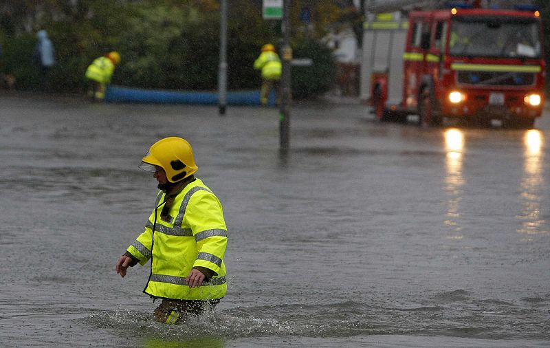 A firefighter wades through flood water in Keswick