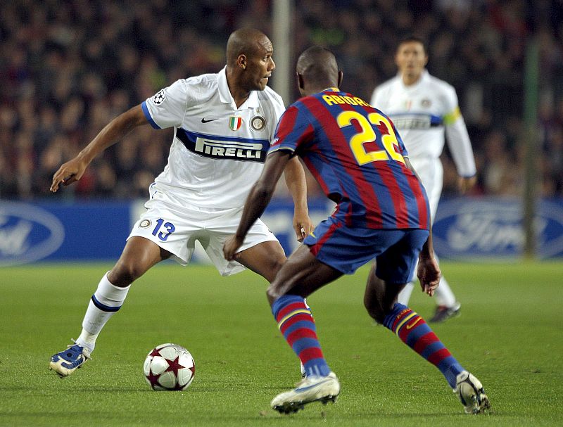 El defensa francés del FC Barcelona, Eric Abidal, intenta evitar el avance del defensa brasileño del Inter de Milán, Sisenando Maicon.