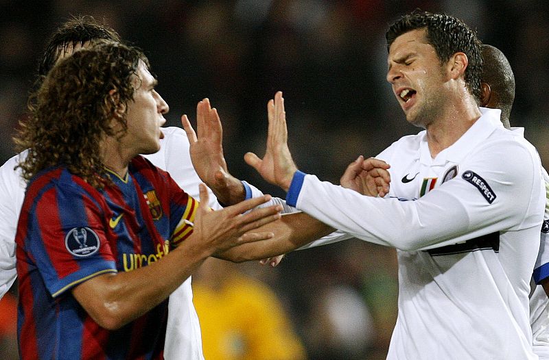 Puyol discute con Motta en un lance del encuentro.