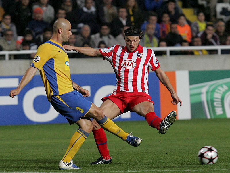 Paulo Jorge del FC Apoel lucha por el balón con el defensa checo Atlético de Madrid Tomas Ujfalusi.