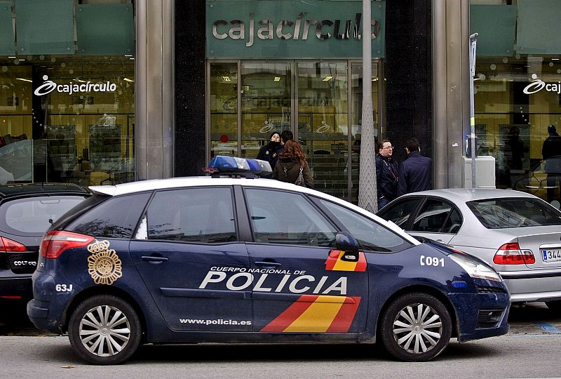 Un coche de policía espera frente a la fachada de Cajacírculo.