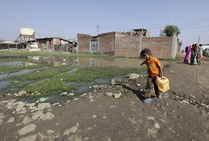 Una niña transporta agua cerca del área afectada por el escape tóxico, en la que se calcula que podría haber unas 5.000 toneladas de residuos tóxicos.