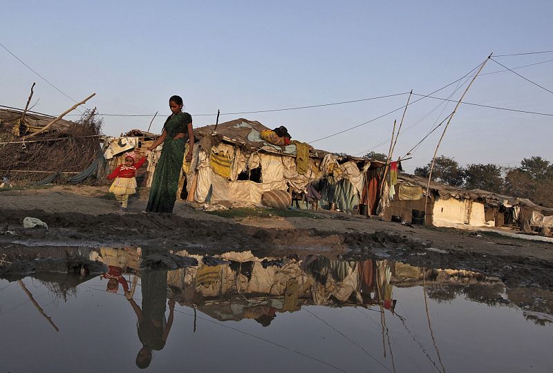 Una mujer camina junto a su hijo en un barrio marginal, cerca de la planta pesticida de la corporación Union Carbide, en Bhopal.