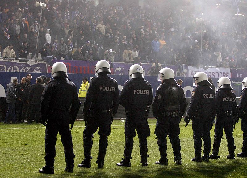 Los policías forman un cordón de seguridad ante la invasión de campo.