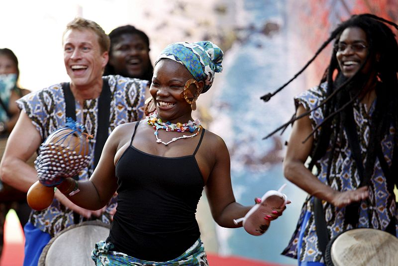 Un grupo de artistas actúan en la alfombra roja de la ceremonia del sorteo de grupos.