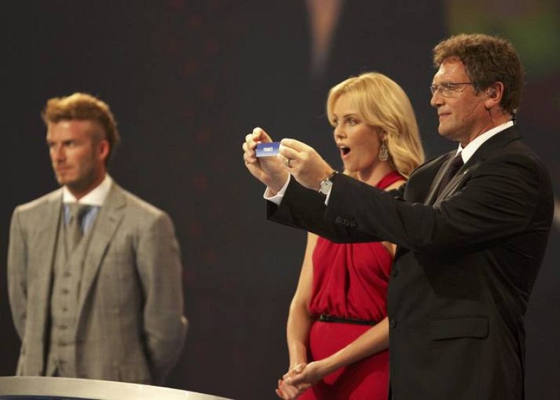 El secretario general de la FIFA, Jerome Valcke, sostiene la papeleta de Francia mientras Charlize Theron y Beckham observan.