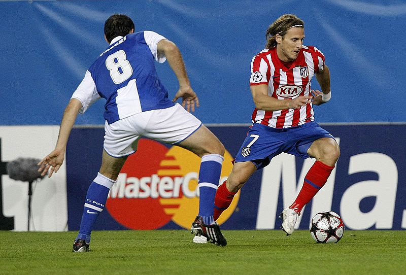 El delantero uruguayo del Atlético de Madrid Diego Forlán, es perseguido por el centrocampista argentino del Oporto Diego Valeri.