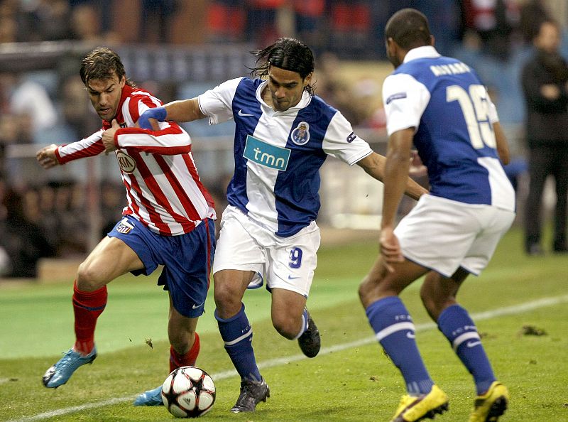 El centrocampista del Atlético de Madrid Juan Valera, lucha un balón con los jugadores del Oporto, el colombiano Radamel Falcao, y el uruguayo Álvaro Pereira.