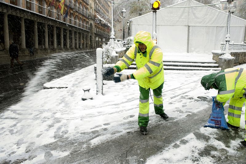 Operarios del Ayuntamiento de Toledo esparcen sal en la plaza de Zocodober tras la nevada caída la pasada noche en la capital toledana.