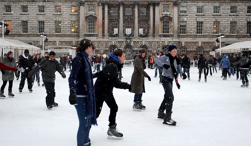 Un grupo de personas patina sobre hielo en la Somerset House bajo la primera nevada del invierno sobre Londres en Reino Unido.