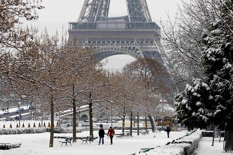 Los parisinos pasean a los pies de la Torre Eiffel en medio de la nieve que ha cubierto la capital francesa.