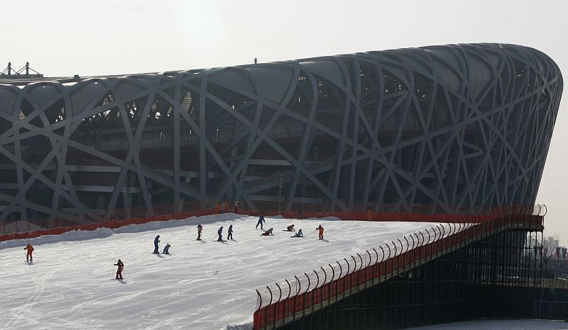 People ski down an artificial slope in front of the national stadium in Beijing