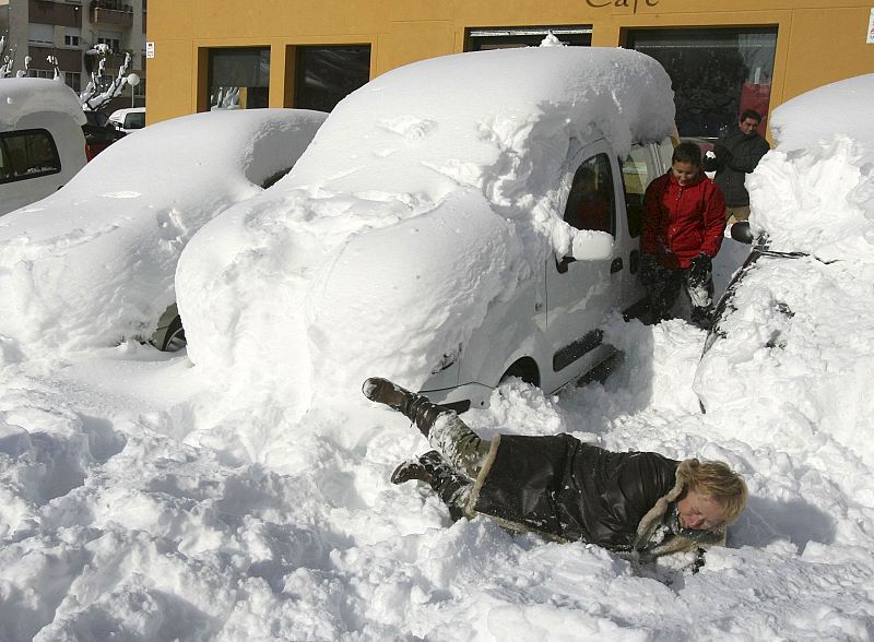 Una vecina de Falset, en Tarragona, cae sobre la nieve acumulada por las intensas nevadas producidas por el temporal que afecta a la zona.