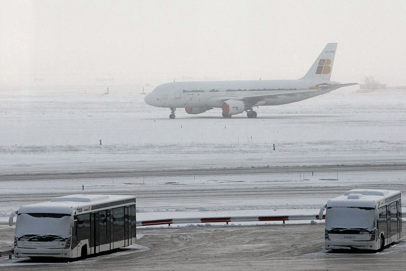 Un Airbus 320 de Iberia, cubierto de nieve mientras permanece aparcado frente a la T-2 del aeropuerto de Barajas.