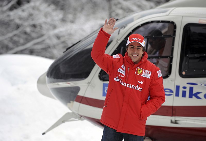 Fernando Alonso saluda tras llegar en helicóptero a la presentación de Ferrari en los Alpes.