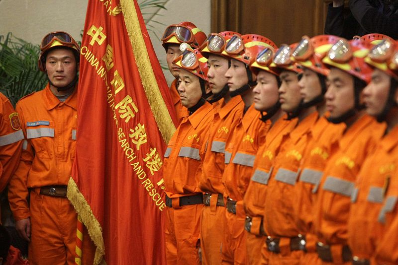 Members of China International Search and Rescue Team stand in a line during a departure ceremony at Beijing airport