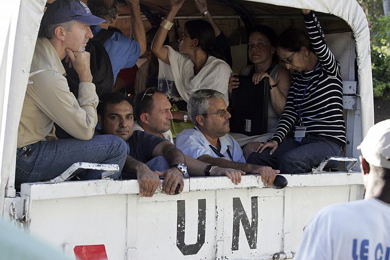 Participantes de la misión de la Onu en Haití (MINUSTAH) consiguen salir de entre las ruinas del edificio oficial.