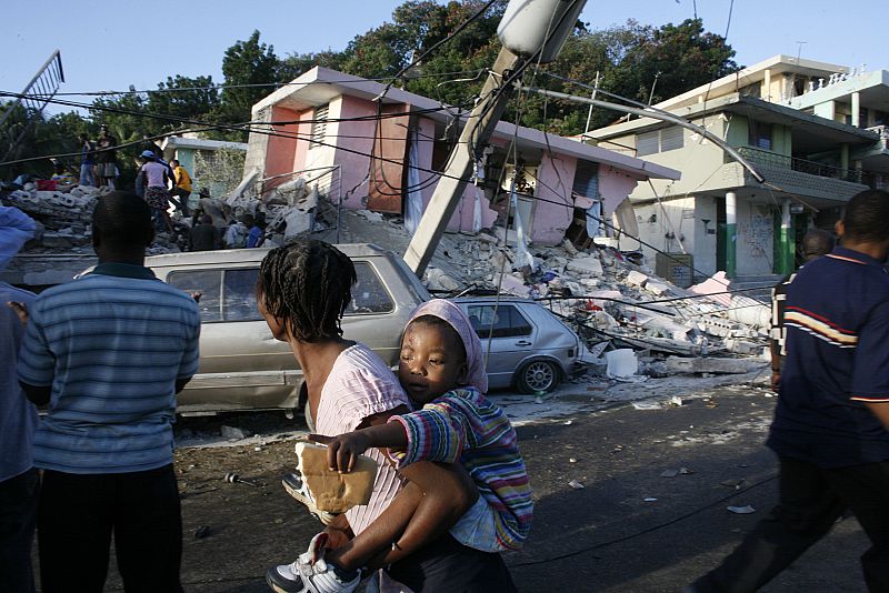 People walk past destroyed buildings after an earthquake in Port-au-Prince