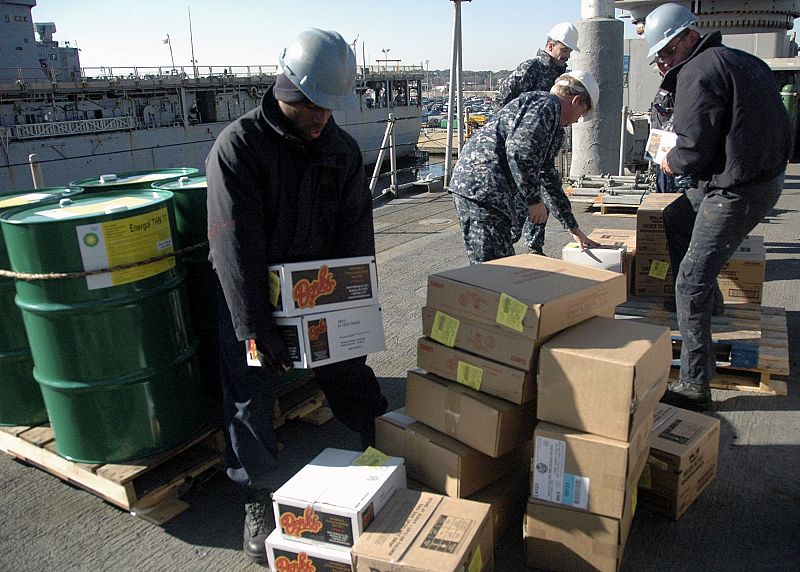 Sailors load supplies aboard the amphibious dock landing ship USS Fort McHenry in Little Creek