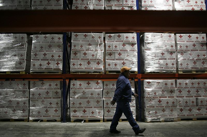 A Red Cross worker walks past humanitarian aid boxes, that will be sent to Haiti, at the Red Cross Center in Toluca