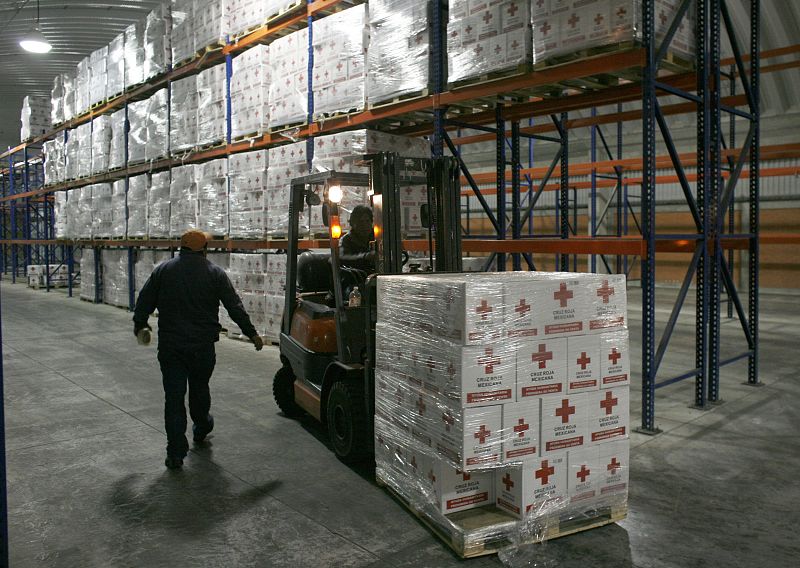 A Red Cross worker loads humanitarian aid boxes to be sent to Haiti at the Red Cross Center in Toluca