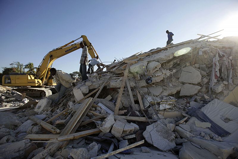 People search for victims in a destroyed building in after the earthquake in Port-au-Prince