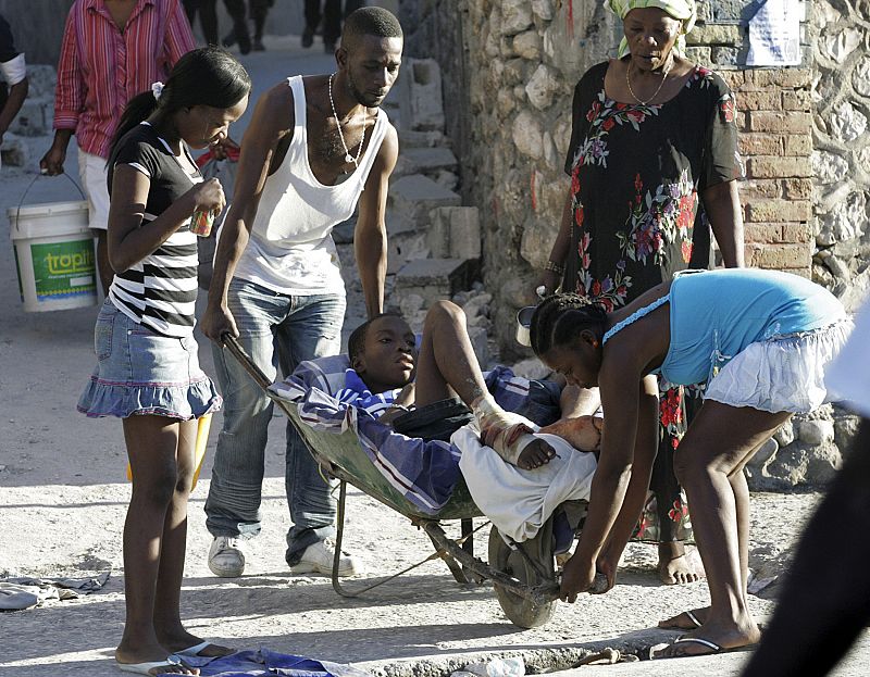 Residents help an injured man in Port-au-Prince