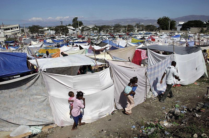 Residents walk at an open camp area where they are staying at after a major earthquake hit the capital Port-au-Prince