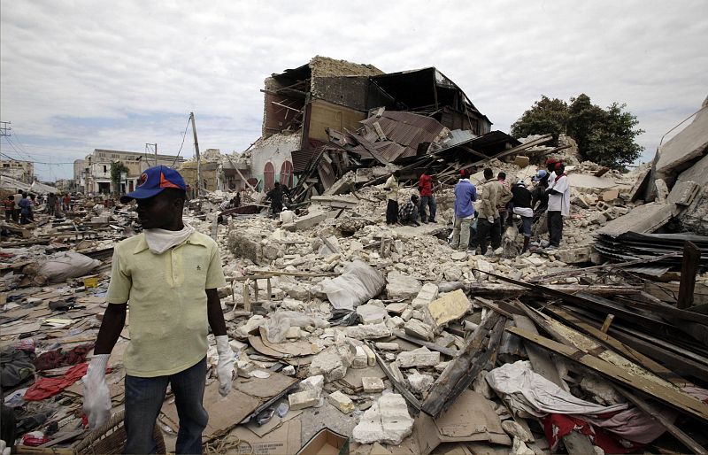 Residents stand among debris after a major earthquake hit the capital Port-au-Prince