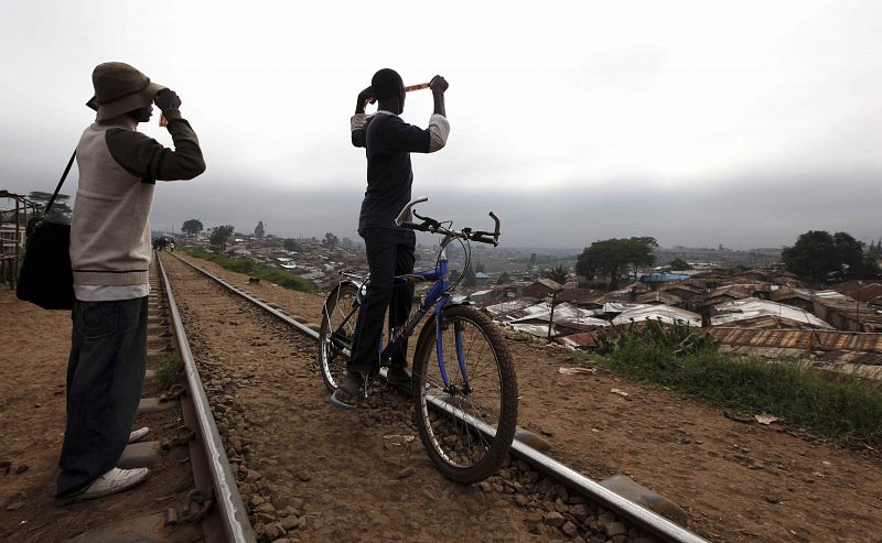 En Kenia dos jóvenes utilizan películas fotográficas para observar el eclipse anular.