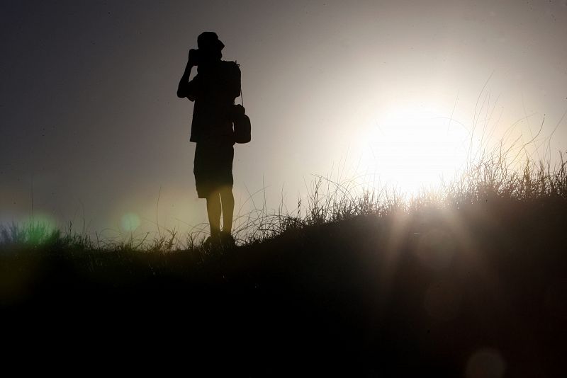 Un fotógrafo permanece a la espera de los competidores del Dakar.10