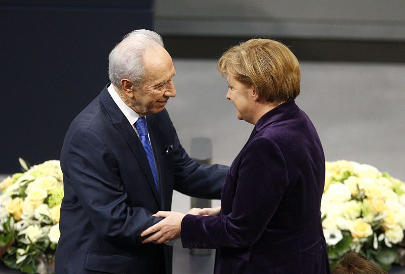 El presidente israelí, Simon Peres, saluda a la canciller alemana, Angela Merkel, después de su discurso en el Bundestag en Berlín.