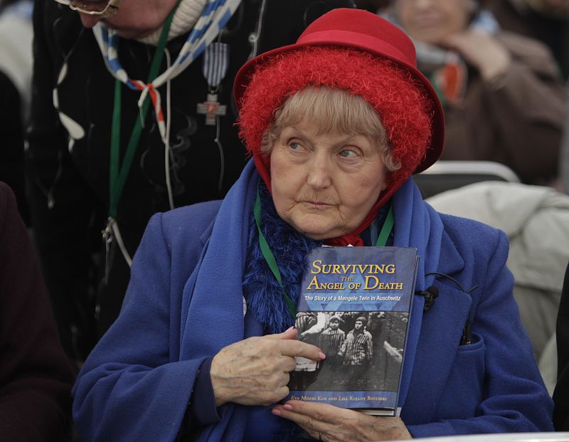 Una superviviente del campo de concentración Auschwitz-Birkenau sostiene un libro con su foto durante la ceremonia que conmemora el 65º aniversario del Holocausto.