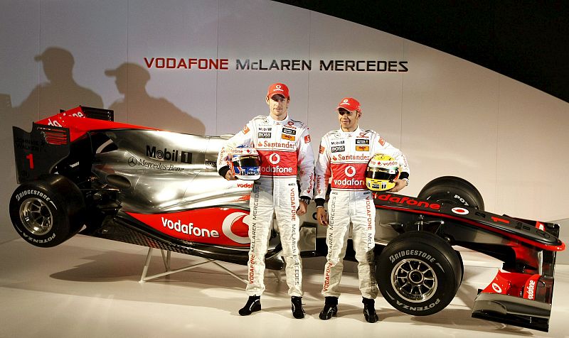 Los pilotos británicos Lewis Hamilton (dcha) y Jenson Button (izda) posan junto al nuevo coche de Fórmula Uno Vodafone McLaren Mercedes MP4-25