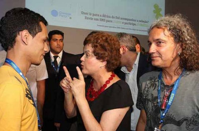 La candidata Dilma Rouseff saluda a un campusero tras su rueda de prensa.