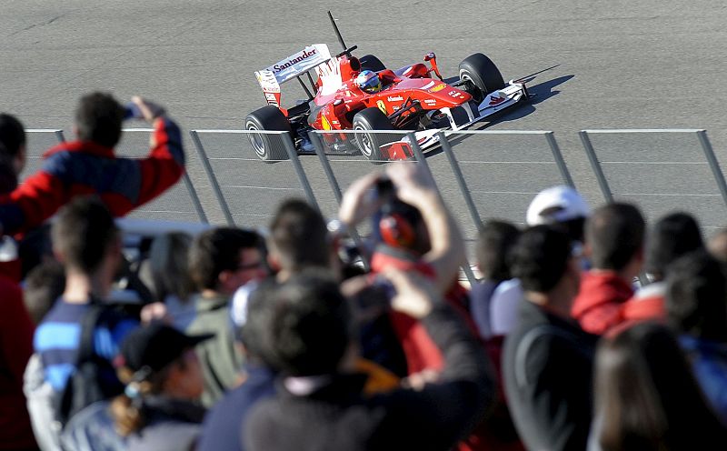 Fernando Alonso recorre la pista, al volante del F10, frente a la grada principal repleta de aficionados