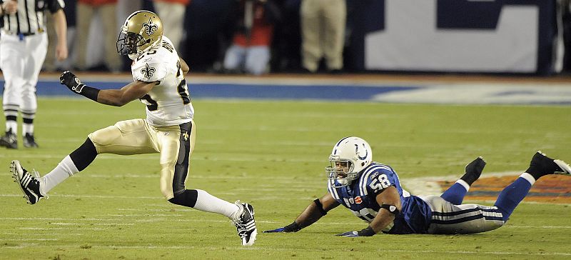 El corredor de los Santos de Nueva Orleans Reggie Bush (i) escapa de la marca de Gary Brackett (d) de los Potros de Indianápolis