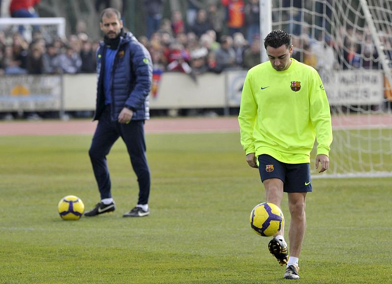 Josep Guardiola observa al centrocampista del club azulgrana Xavi Hernández durante un entrenamiento.