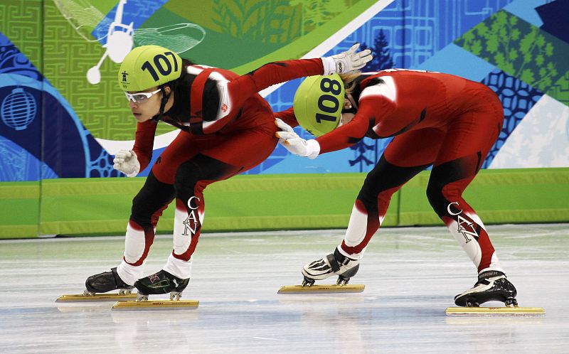 Canada's St-Gelais pushes her team mate Roberge during the women's 3000 meters relay short track speed skating semi-finals at the Vancouver 2010 Winter Olympics