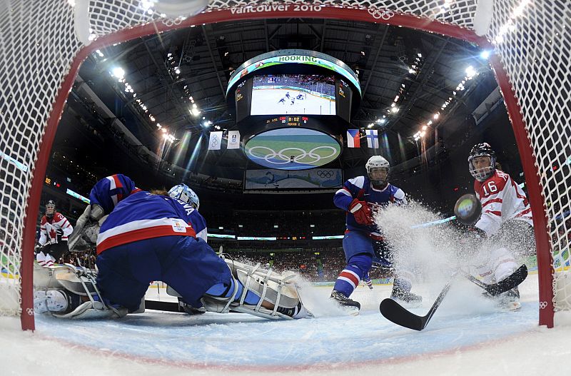 Canadian Hefford scores against goalie Tomcikova of Slovakia during their women's hockey game at the Vancouver 2010 Winter Olympics