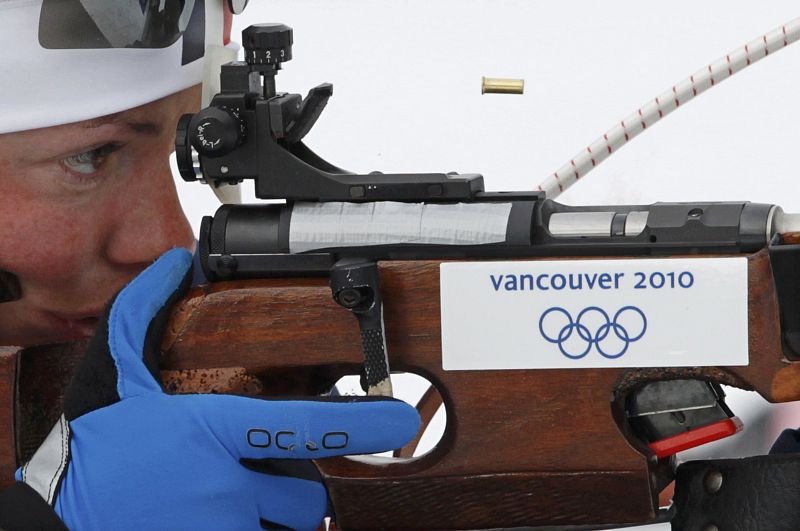A shell casing flies out of Frances Dorin rifle rifle as she shoots during a training session for the womens biathlon event at the Vancouver 2010 Winter Olympics in Whistler
