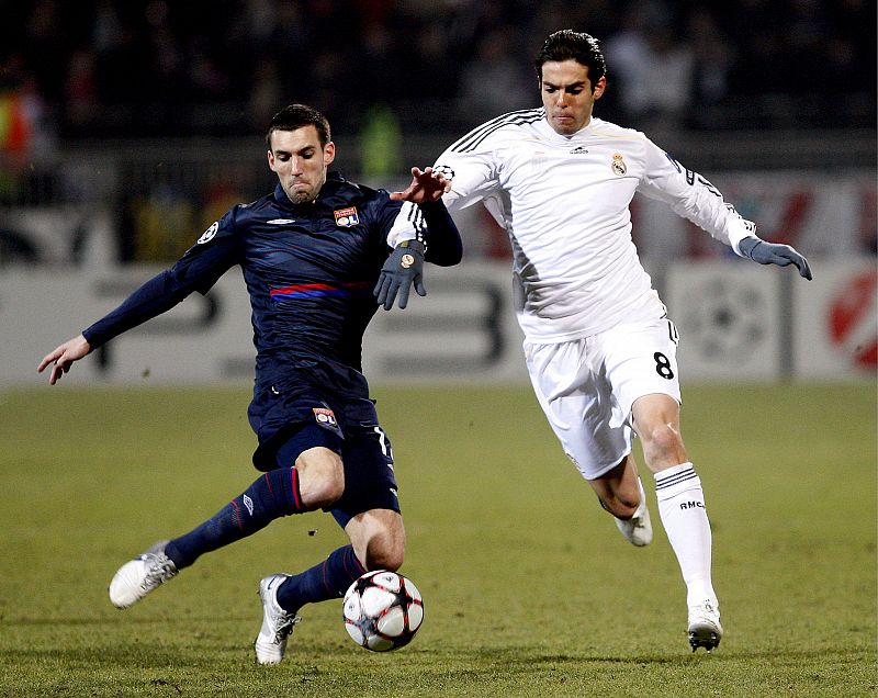 Kaká lucha por el balón con Reveillere.