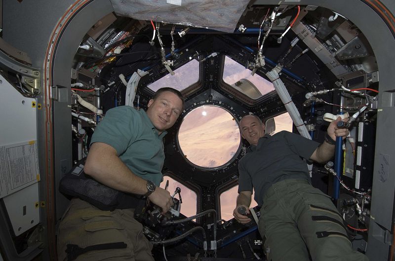os astronautas de la NASA Terry Virts y Jeffrey Williams, posan tras los nuevos ventanales del universo.