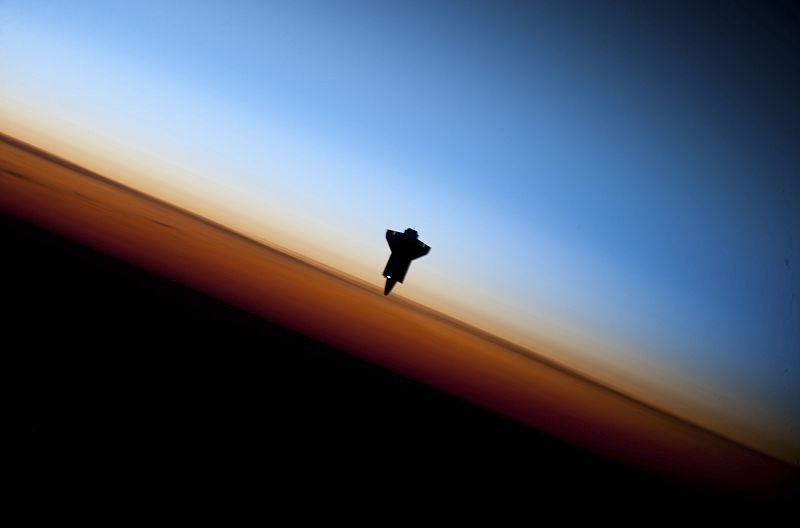 La silueta del Endeavour con la Tierra de Fondo