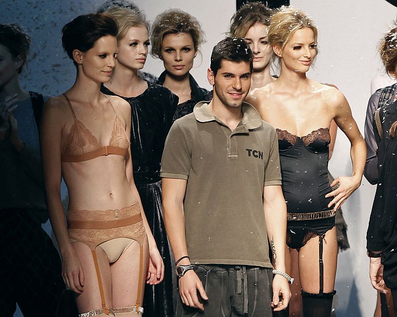 Toro Rosso's Alguersuari poses with models during the Cibeles Madrid Fashion Week Fall/Winter 2010 show in Madrid